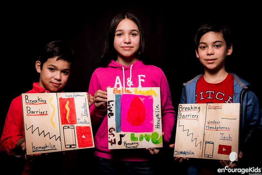 Children showcasing Breaking Barriers project boards